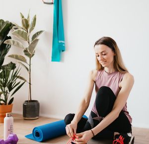 A water bottle and a small towel next to a yoga mat.