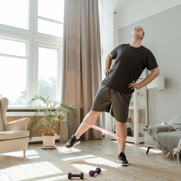 Person stretching in a minimalist room with natural light.